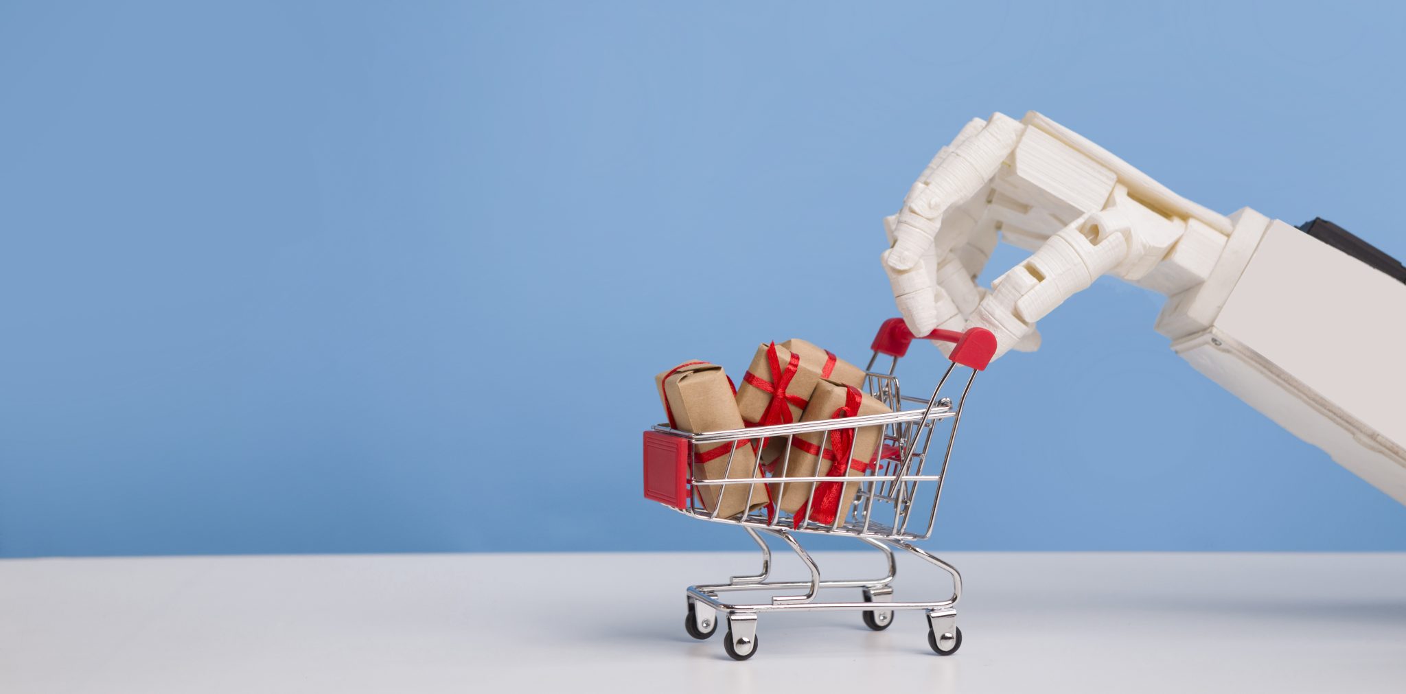 Innovative black friday. Robot hand with shopping cart full of gift boxes, blue background, free space
